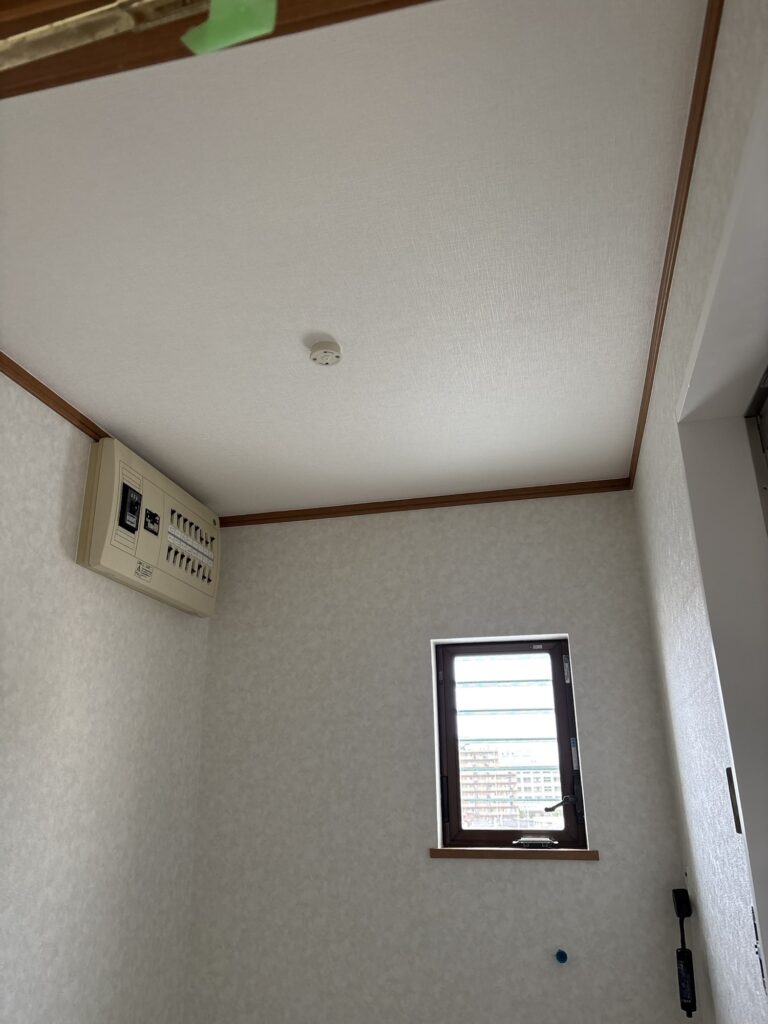 Completed ceiling and wall wallpaper installation in the washroom