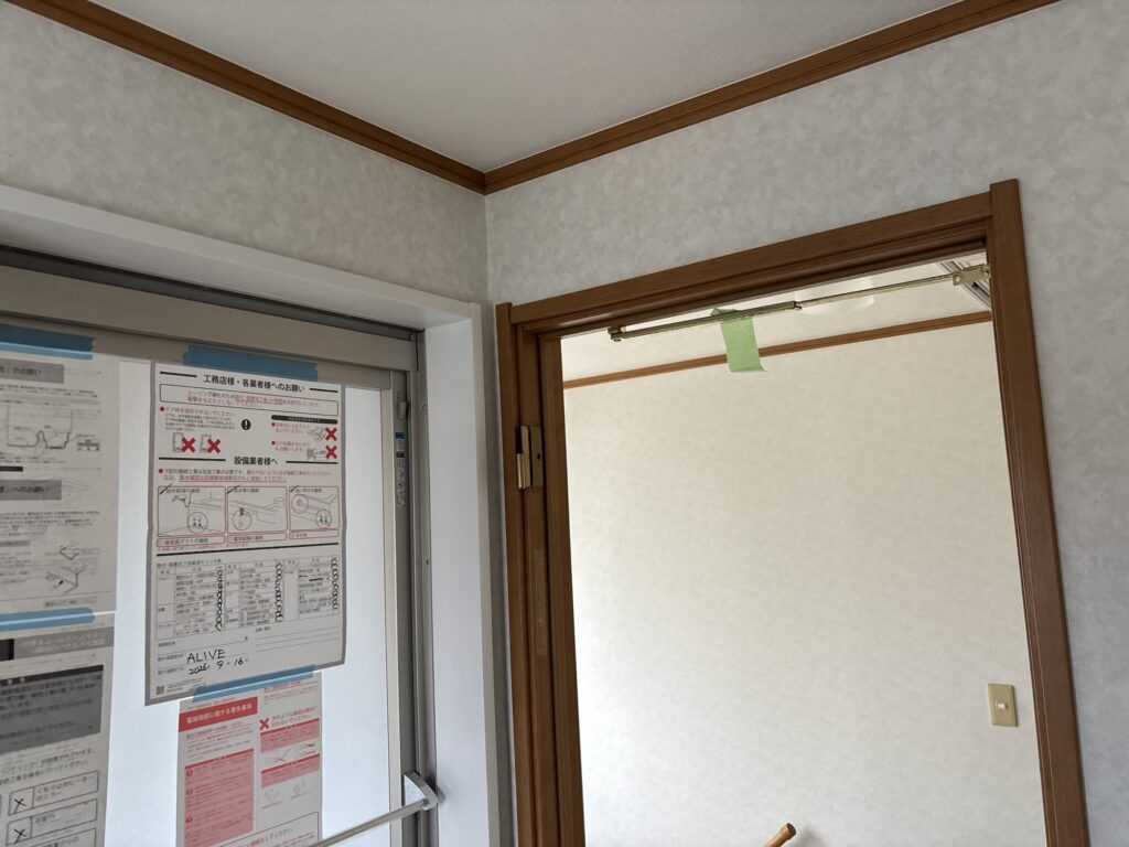 Completed wallpaper installation around the washroom door frame