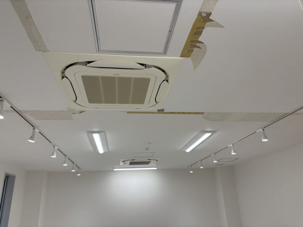 Ceiling-mounted air conditioner with the cover attached in a commercial interior.