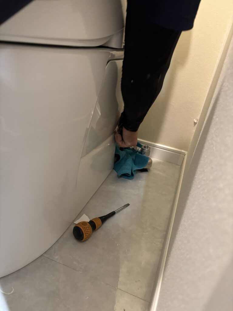 Disconnecting the water supply hose before removing a toilet