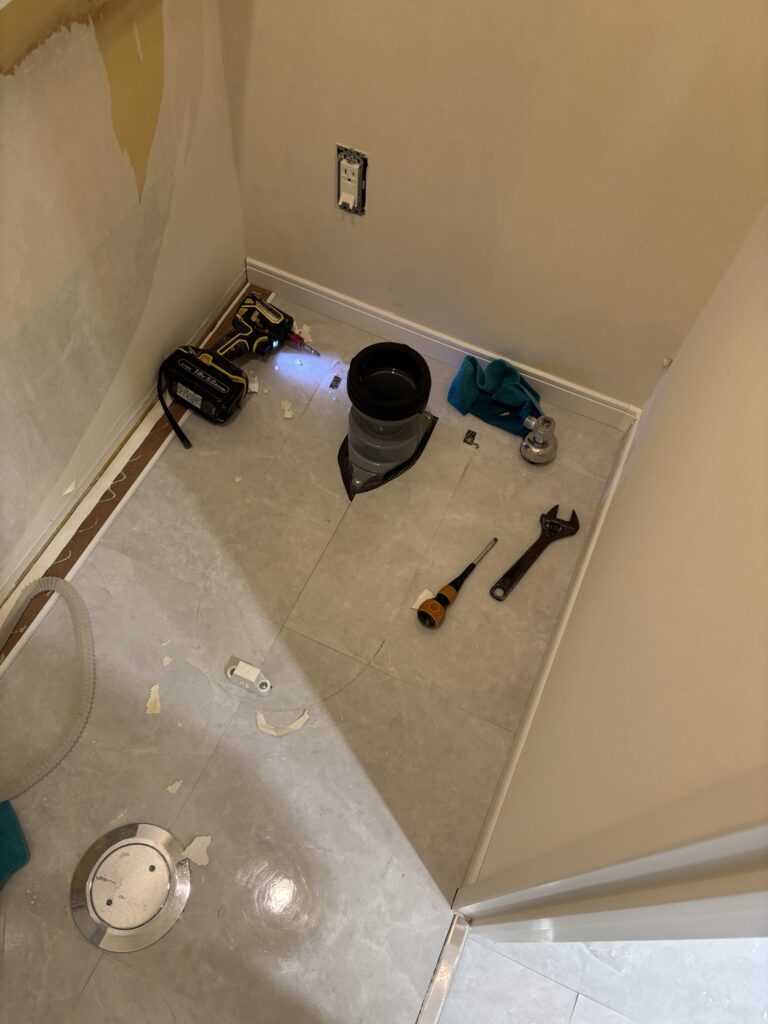 Toilet removed from a commercial bathroom before floor tile installation