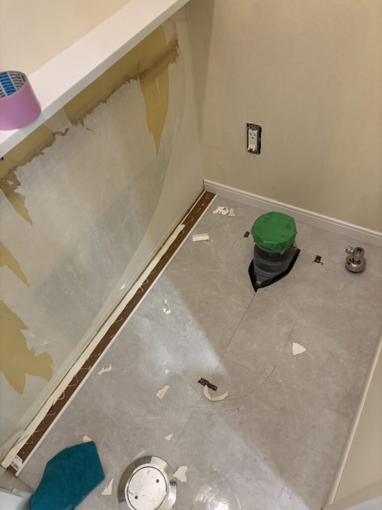 Drain flange opening sealed with protective tape after toilet removal