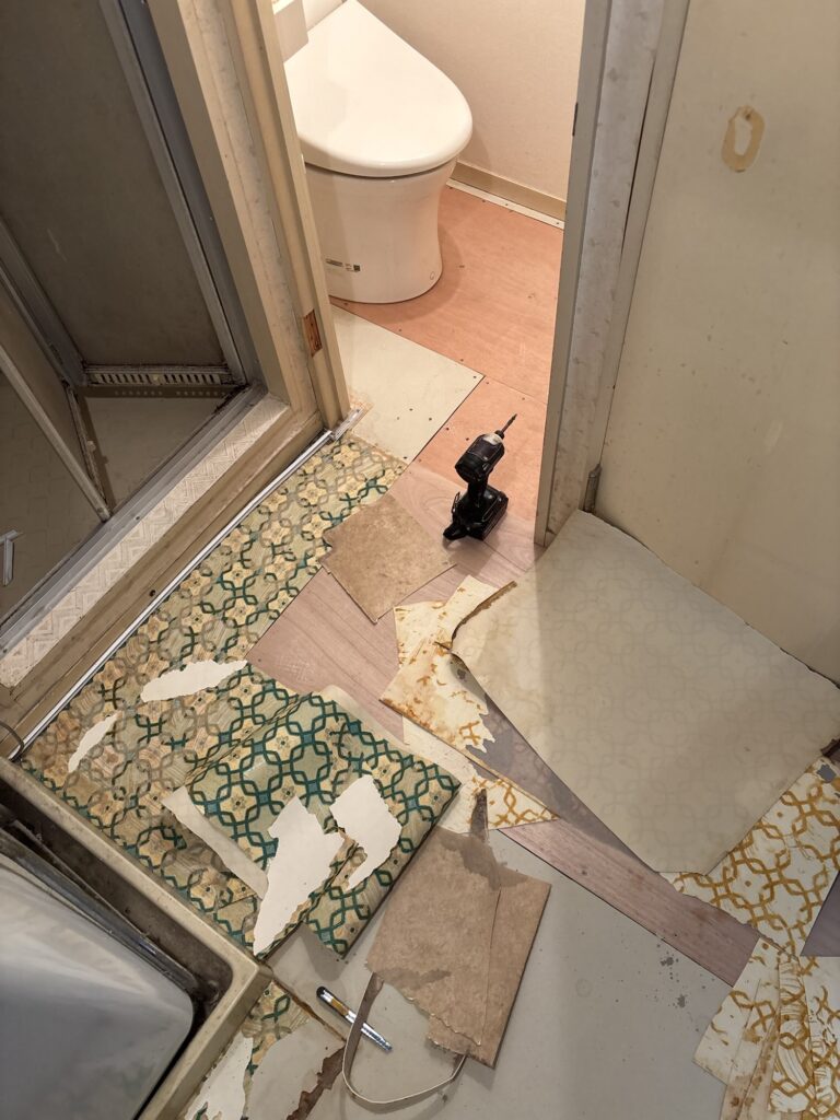 Old cushion flooring being removed from the toilet and washroom floor