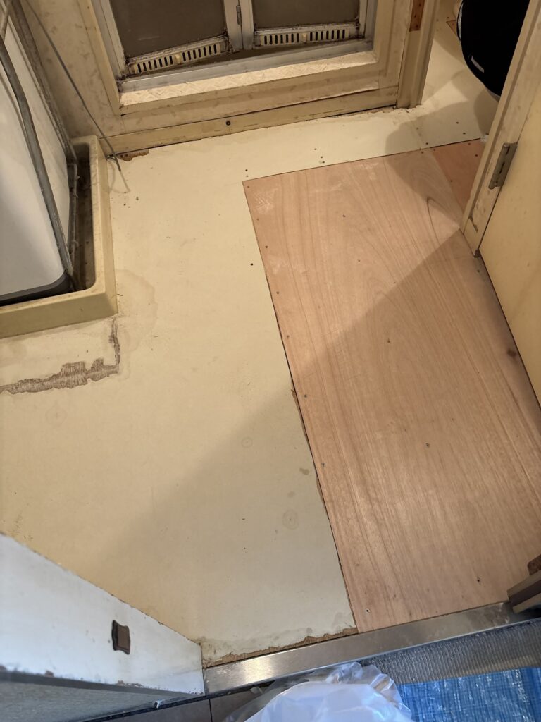 Plywood subfloor exposed after removing the old cushion flooring
