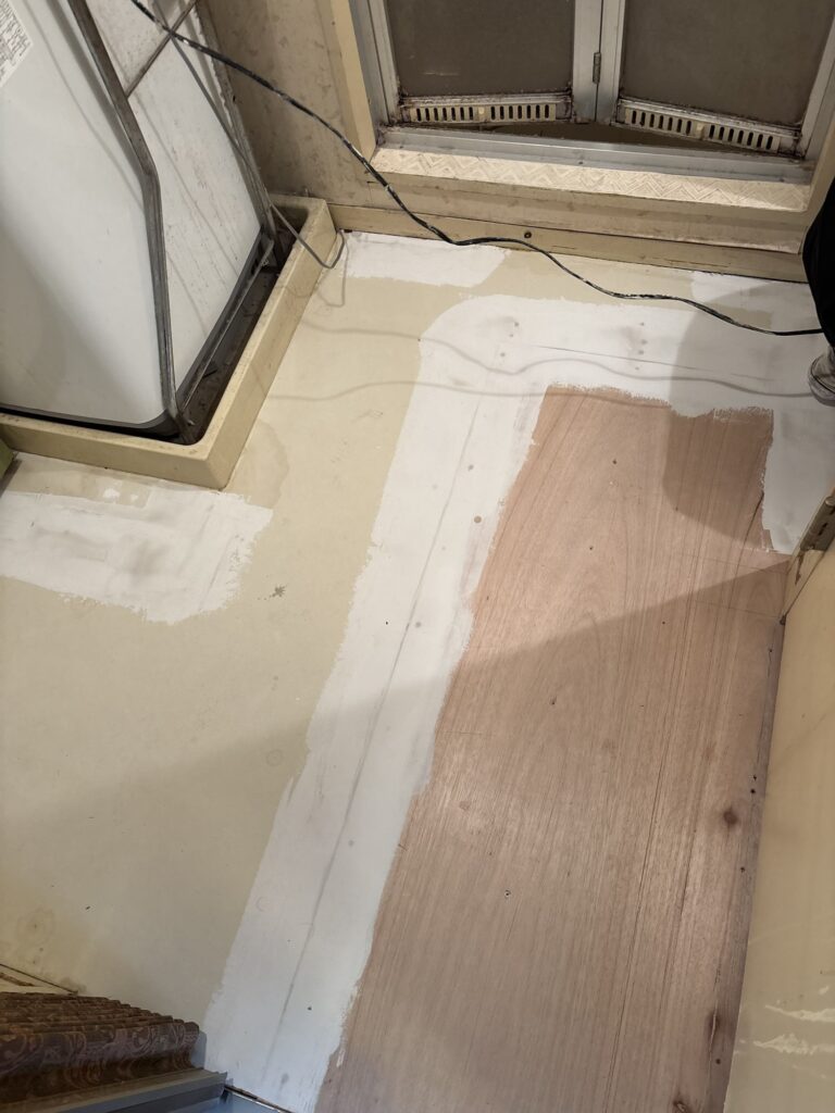 Floor leveling compound applied to the plywood subfloor