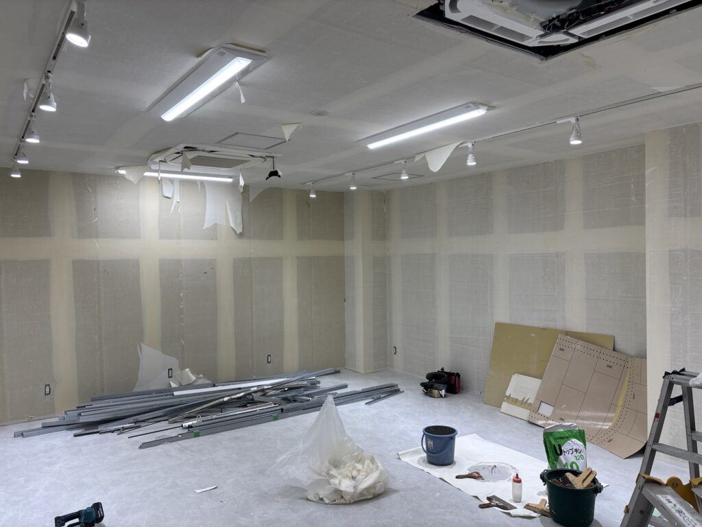 Ceiling lighting fixtures before removal during a commercial wallpaper renovation.