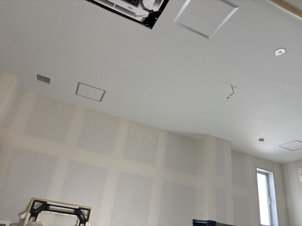 Ceiling wallpaper being installed while wrinkles are carefully smoothed out.