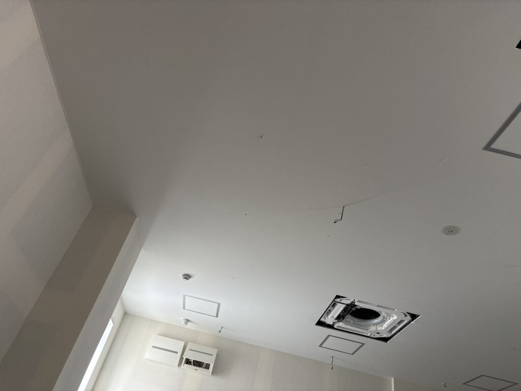Finished smooth white ceiling wallpaper after installation in a commercial building.