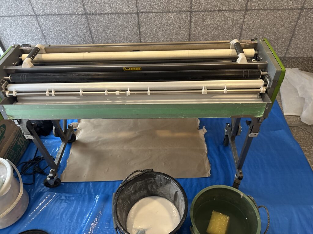 Wallpaper being prepared with a wallpaper pasting machine for an apartment renovation project.