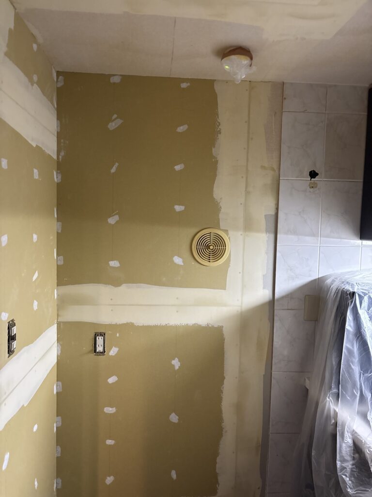 Kitchen walls and ceiling with a finishing coat of joint compound applied before wallpaper installation.
