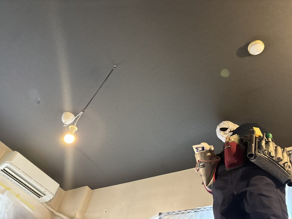 Finished black wallpaper installation on the living room ceiling of an apartment in Tokyo.