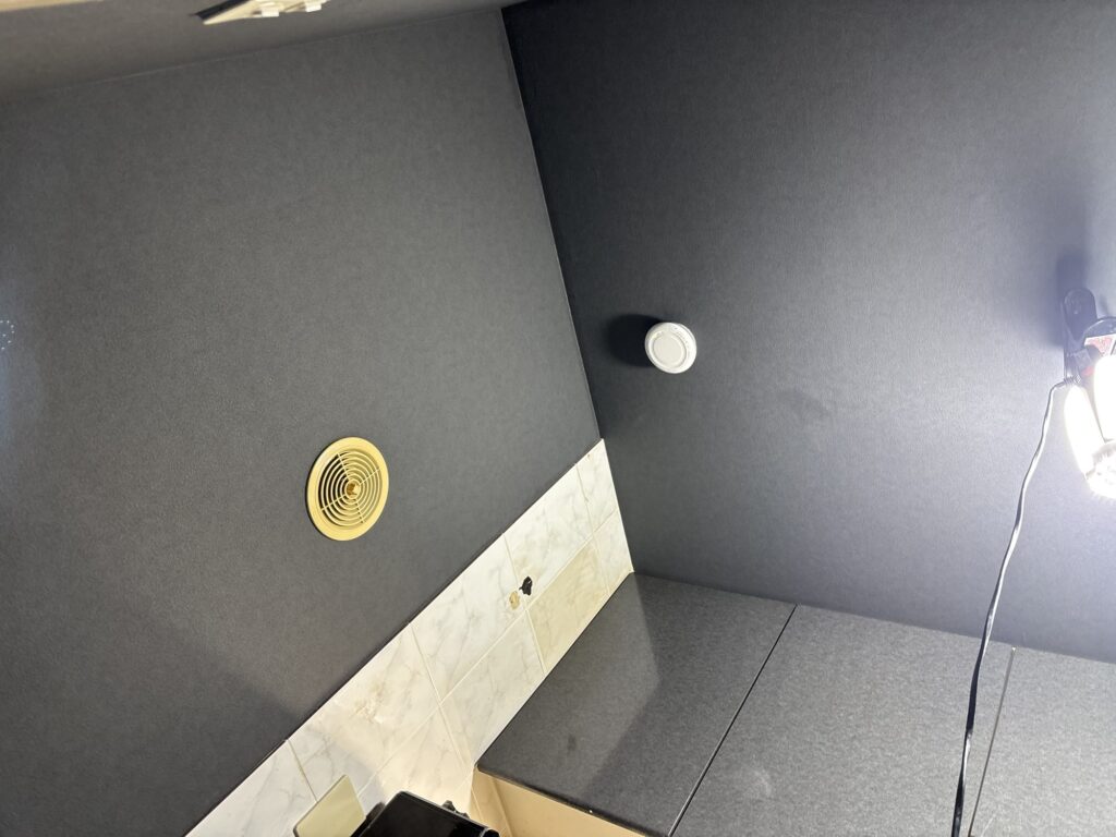 Finished black wallpaper installation on the kitchen walls and ceiling.