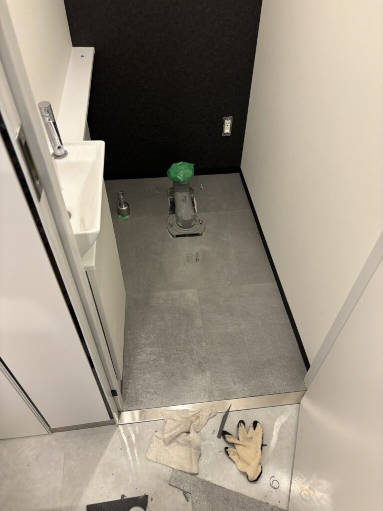 Clean, newly installed vinyl floor tiles covering the toilet floor after renovation.