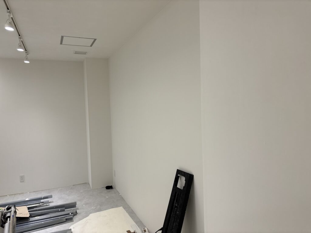 Commercial room with newly installed white wall wallpaper following interior restoration work.
