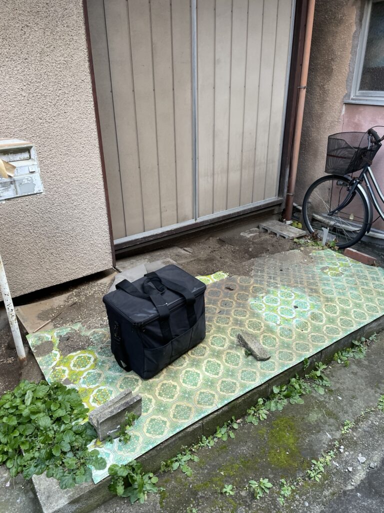 Front yard covered with a sheet before preparing a motorcycle parking area.
