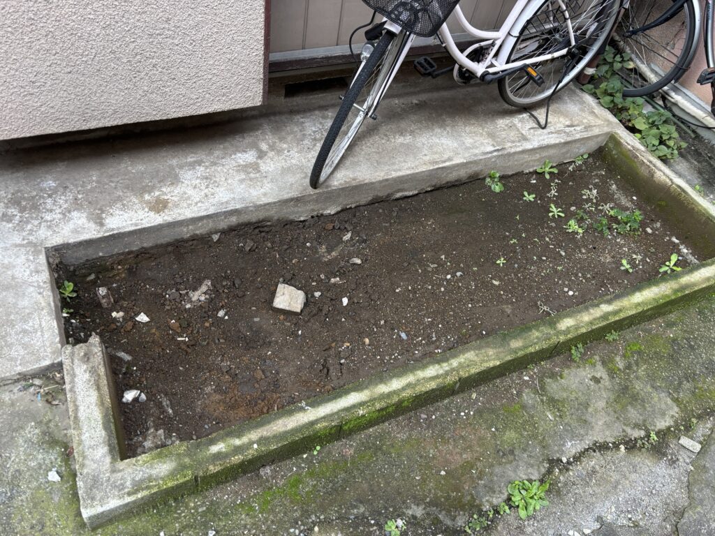 Excavated ground approximately 15 centimeters deep for a DIY concrete motorcycle parking area.