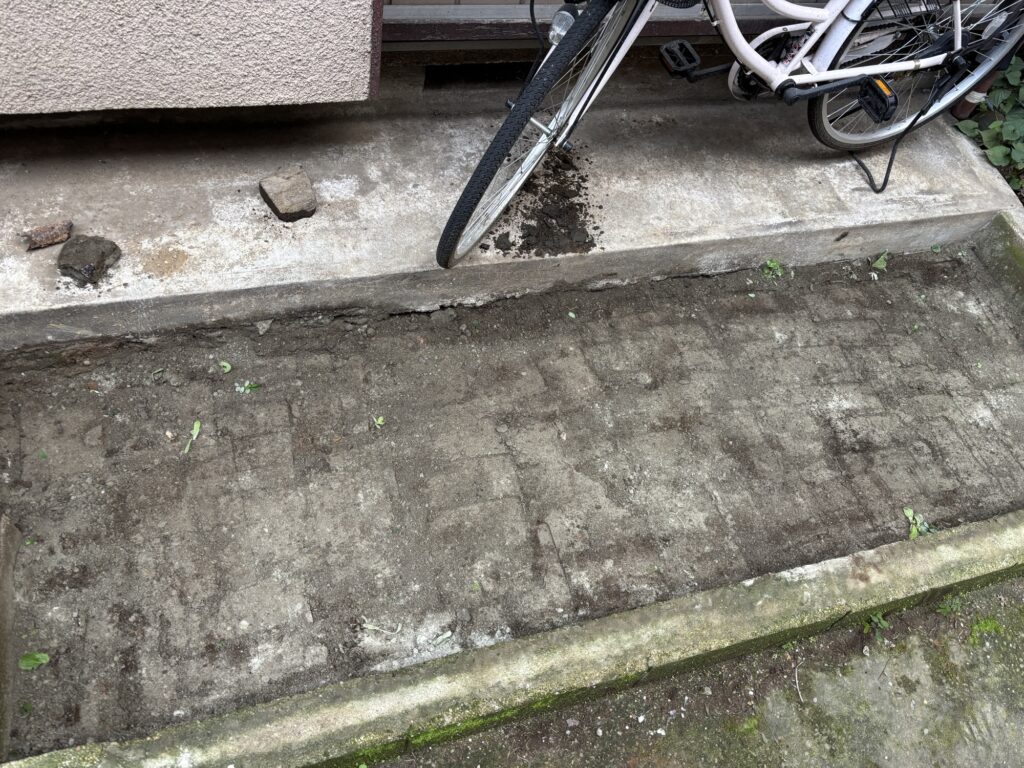 Compacted soil prepared for the gravel base of a motorcycle parking space.