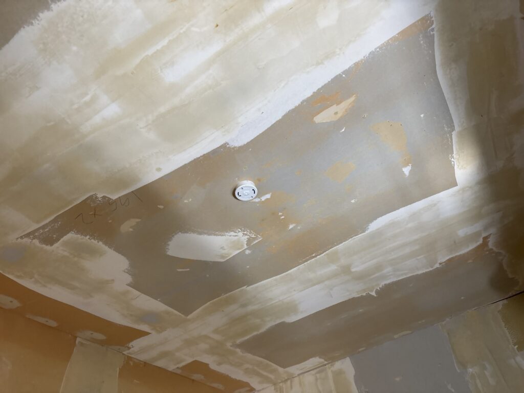 Kitchen ceiling with finishing joint compound applied before new wallpaper installation.