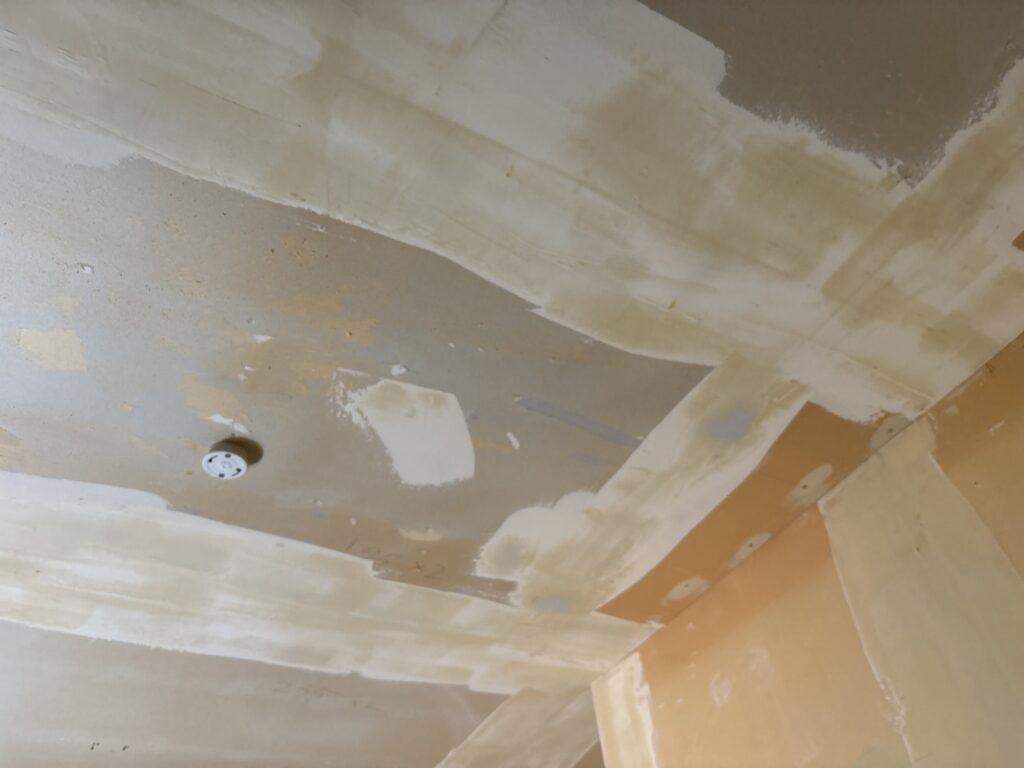 Kitchen ceiling with a smooth finishing coat of joint compound ready for wallpaper installation.