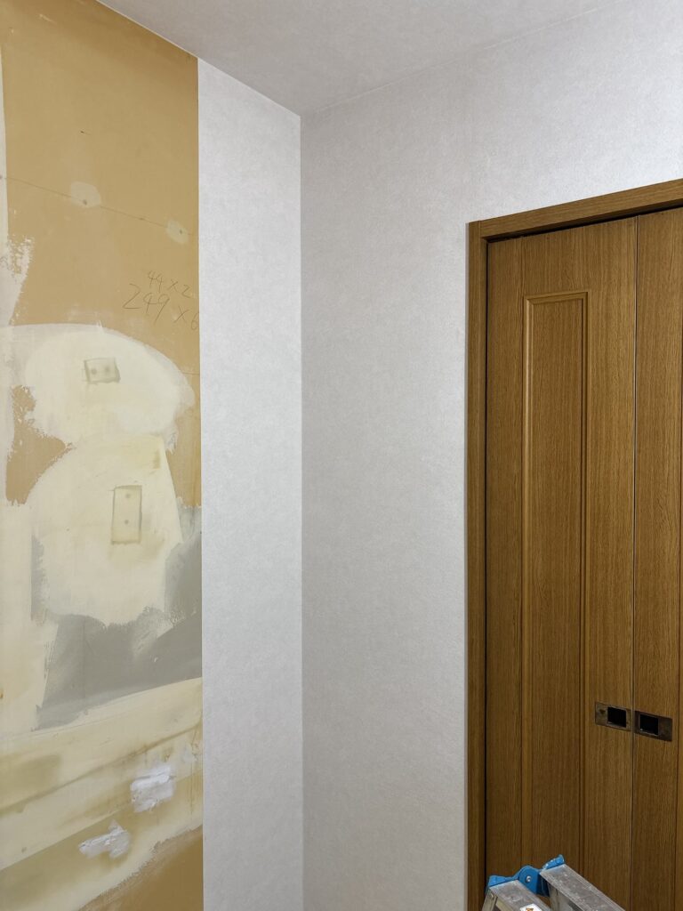 First sheet of new wallpaper installed on a kitchen wall during a professional wallpaper replacement project.