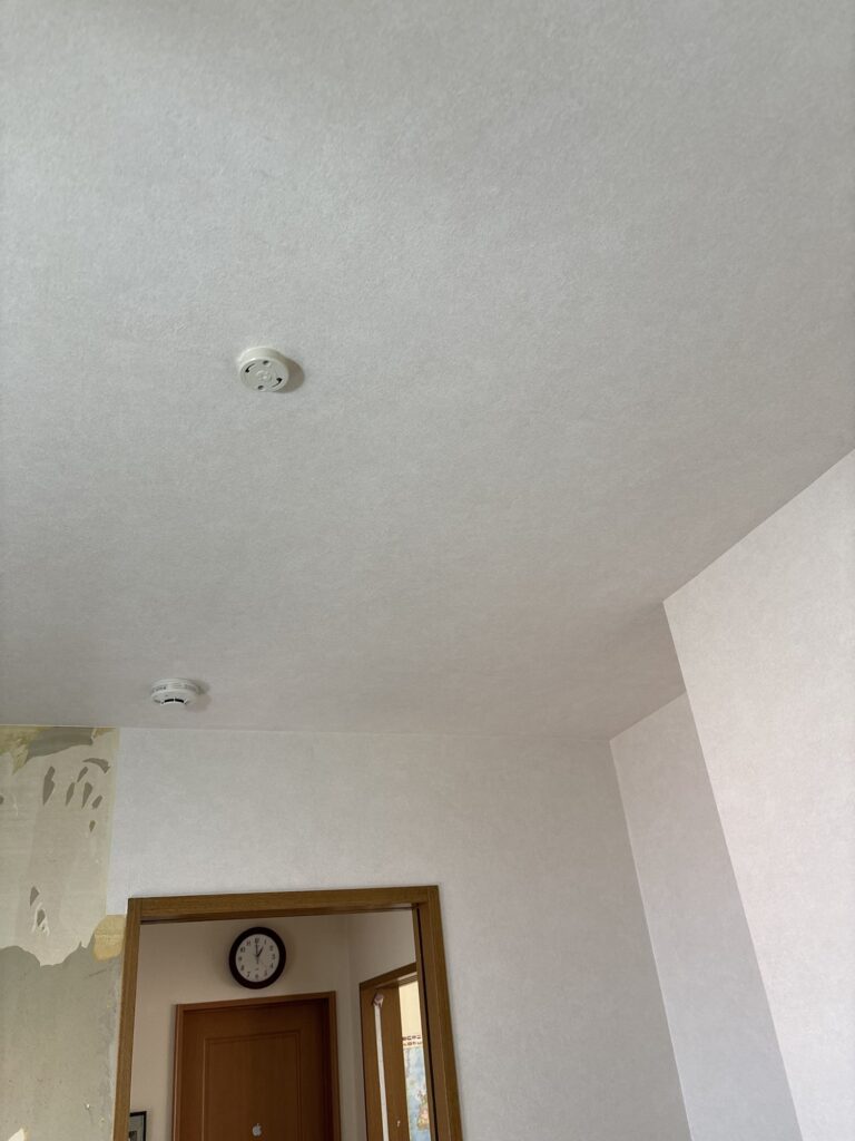 Completed kitchen wallpaper replacement showing the finished ceiling and walls.