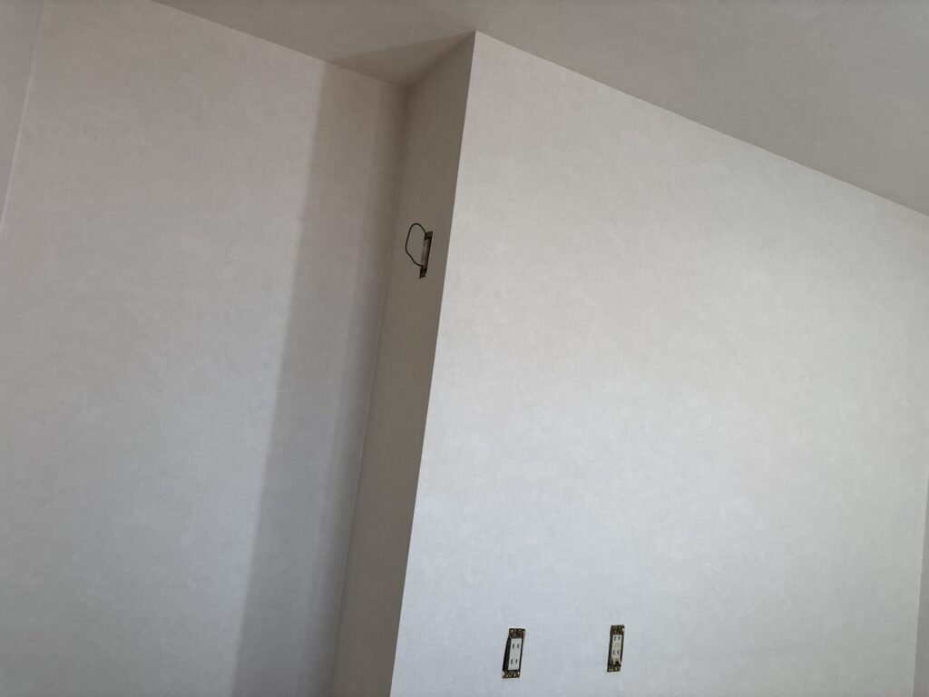 Finished kitchen walls with newly installed wallpaper in a Japanese detached house.