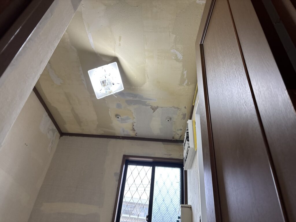 Base joint compound applied to uneven areas around the bathroom entrance frame.
