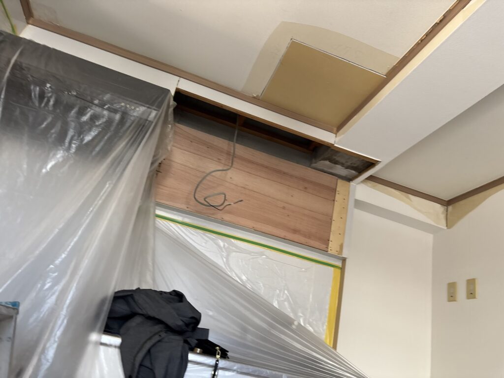 Existing ceiling and walls in the living room before wallpaper renovation.