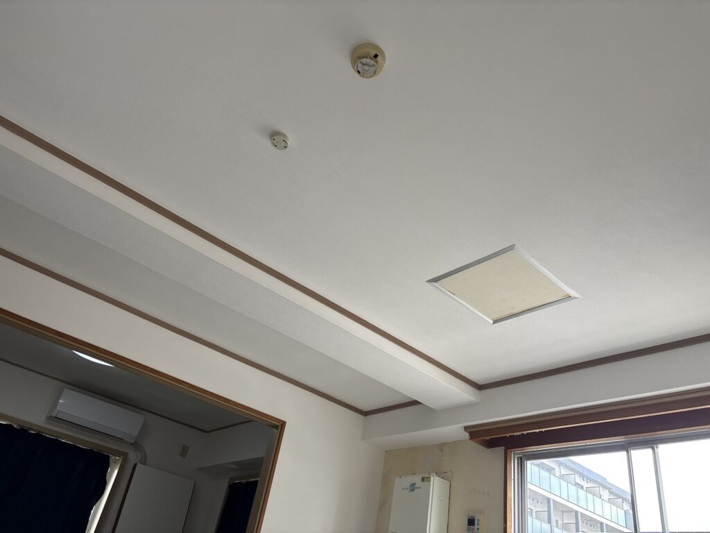 Wide view of the completed patterned wallpaper on the ceiling of an 11th-floor apartment.