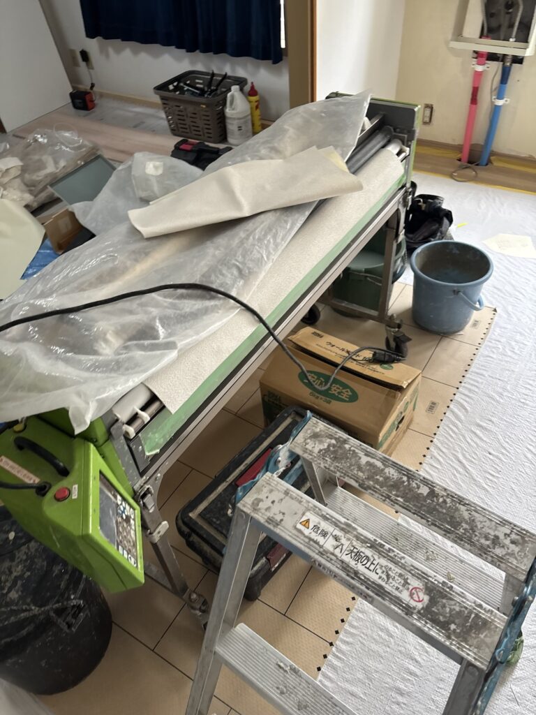 Wallpaper being prepared with a wallpaper pasting machine for an apartment renovation project.