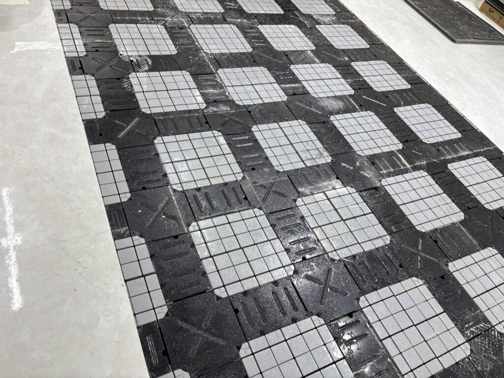 Raised access OA floor visible underneath old vinyl tiles during a commercial flooring renovation.
