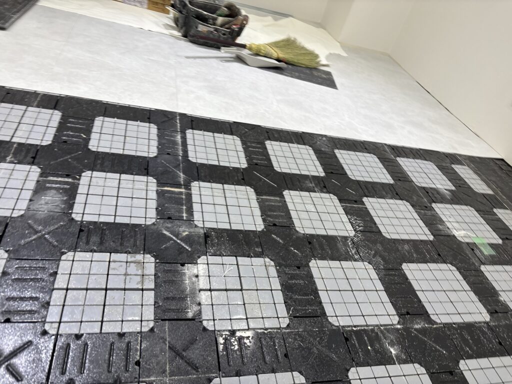 Old vinyl tiles being removed from a commercial store floor before replacement.