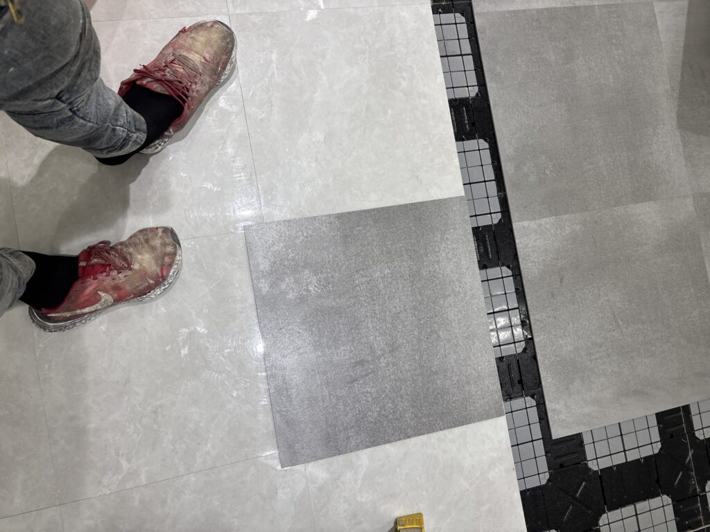 Old and new vinyl floor tiles placed side by side to show the difference in size.
