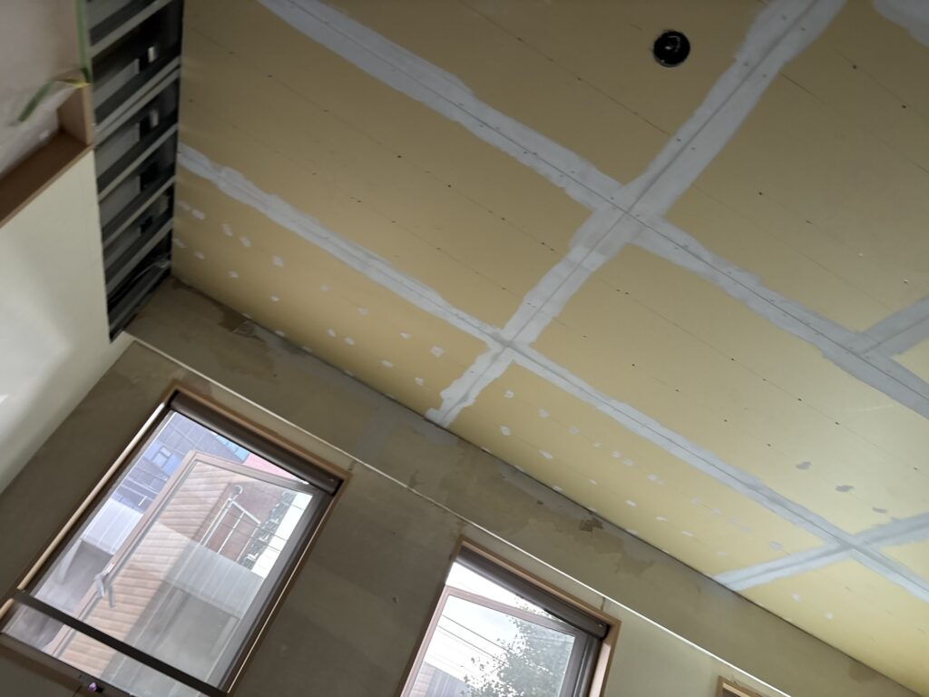 Living room ceiling with base coat putty applied to the gypsum board joints.