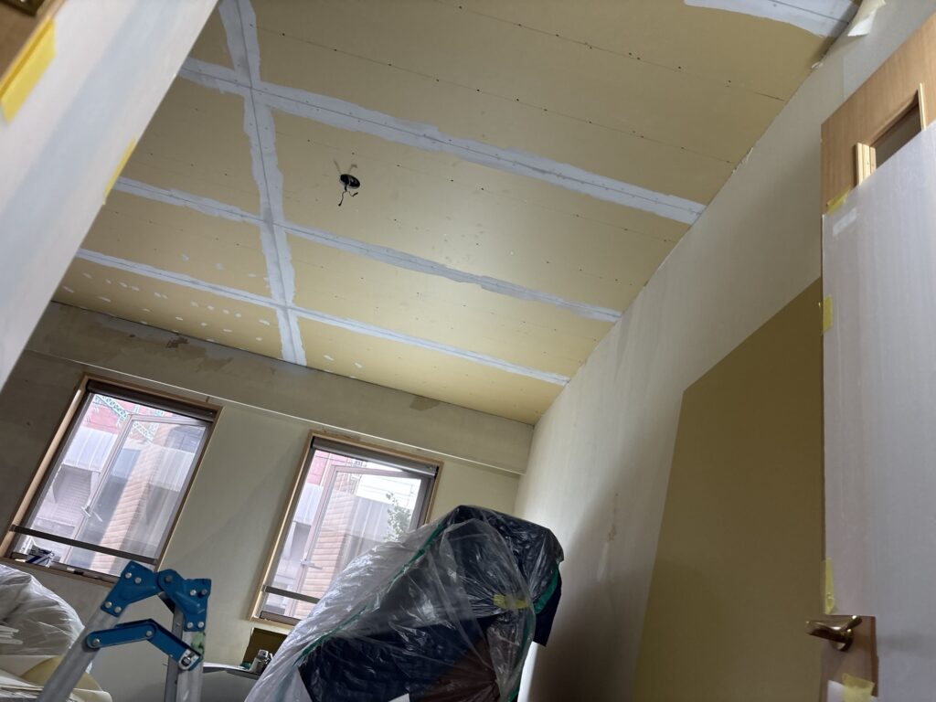 Base coat putty covering the joints between ceiling boards in the living room.