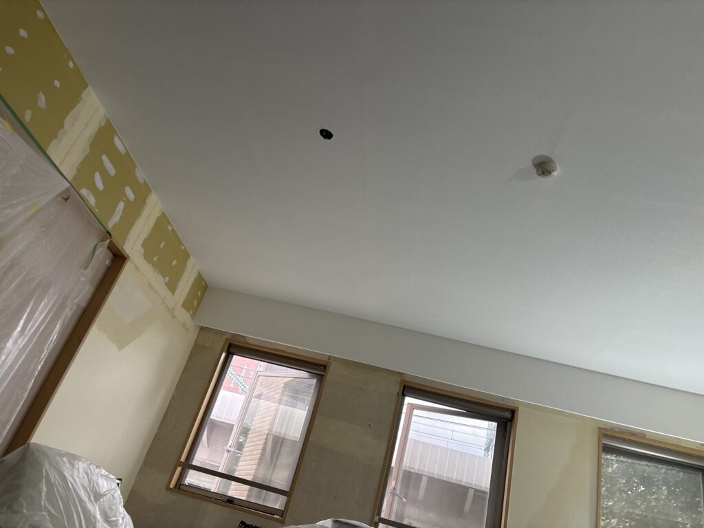 Second view of the completed wallpaper installation on the living room ceiling in a 2LDK apartment.