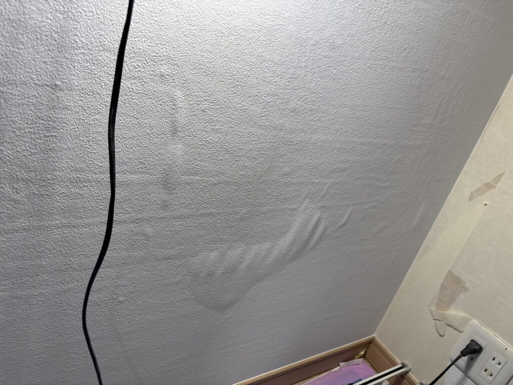 Wallpaper backing paper temporarily swelling after absorbing moisture from wallpaper adhesive in a Japanese apartment.