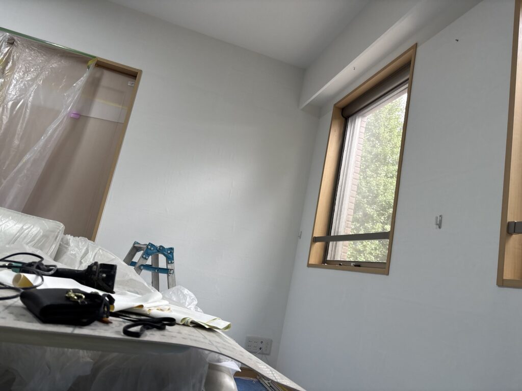 Completed wallpaper installation on the living room walls of a Japanese apartment.