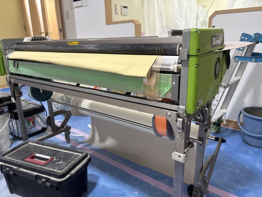 Wallpaper pasting machine used to apply adhesive and prepare wallpaper for installation in Japan.