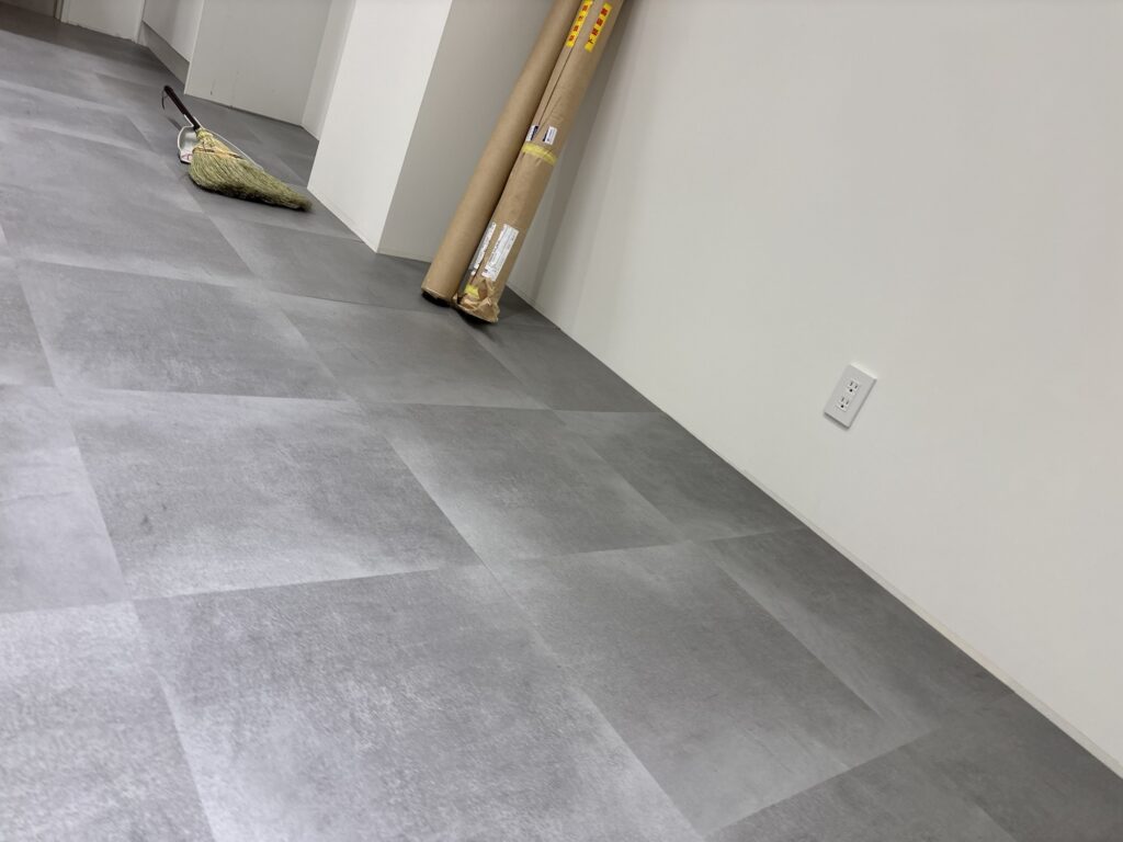 Finished commercial floor with newly installed square floor tiles arranged in straight, aligned rows.