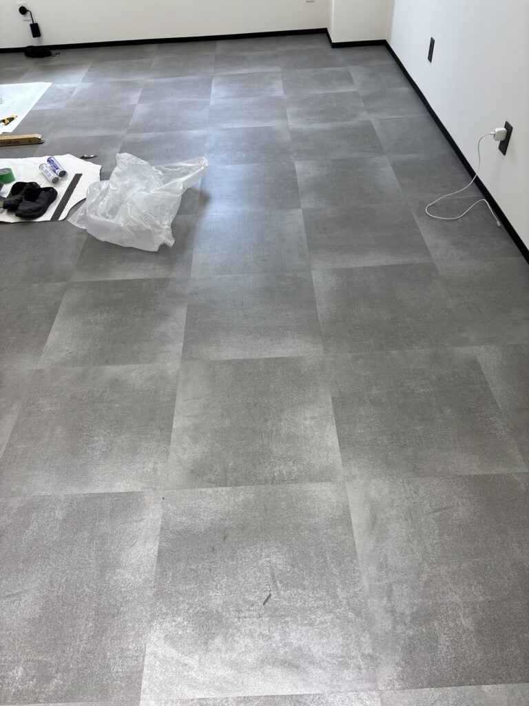 Completed soft baseboard installation along the bottom of the walls above the newly installed floor tiles.
