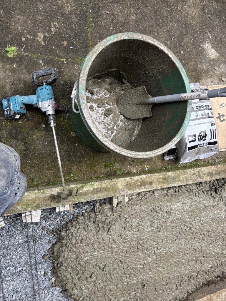 Partially poured concrete slab during the construction of a motorcycle parking area.