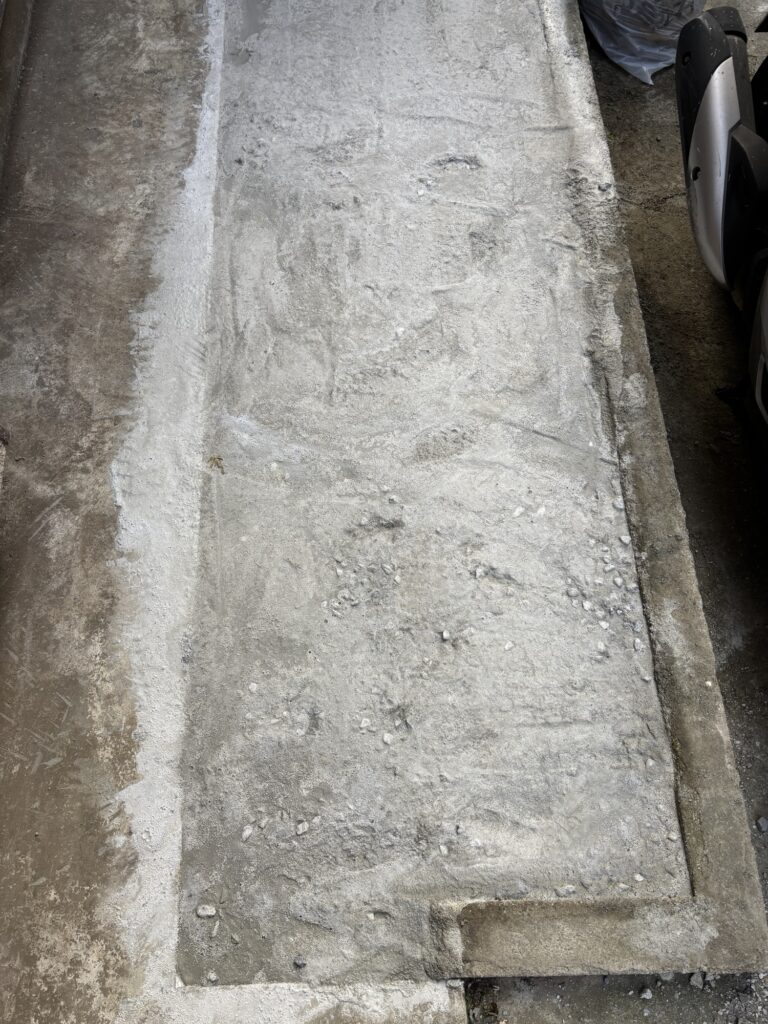 Finished concrete slab in front of a Japanese house for motorcycle parking.