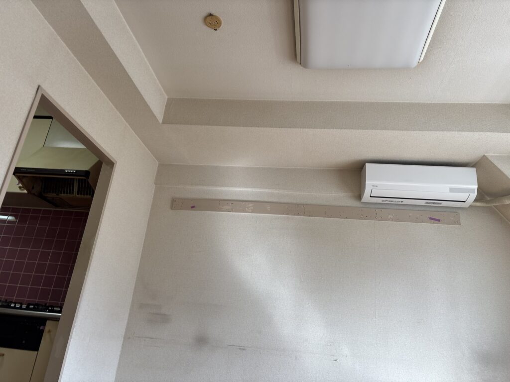 Close-up view of a wooden nageshi wall rail before removal during an apartment renovation in Japan.