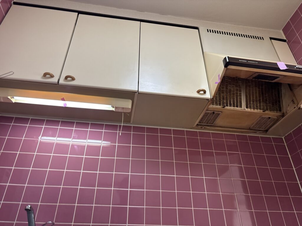 Existing kitchen range hood and under-cabinet light before removal during a condominium renovation.